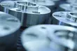 Close-up of precision metal components with smooth, polished surfaces arranged in rows for industrial manufacturing.